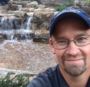 Mike Herrmann with backyard pond waterfall