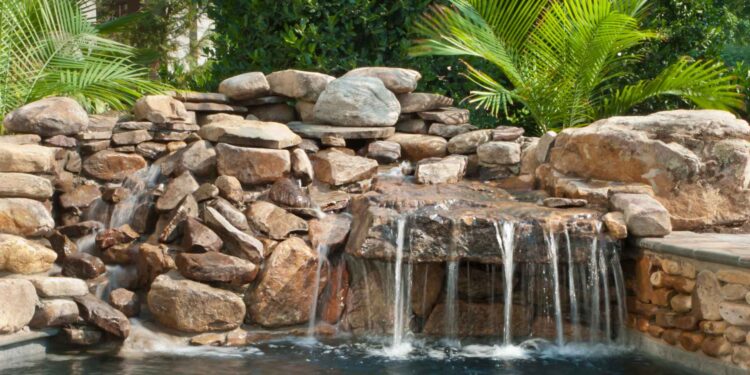 Beautiful backyard pond with a waterfall feature, showcasing the importance of choosing the right pond pump.