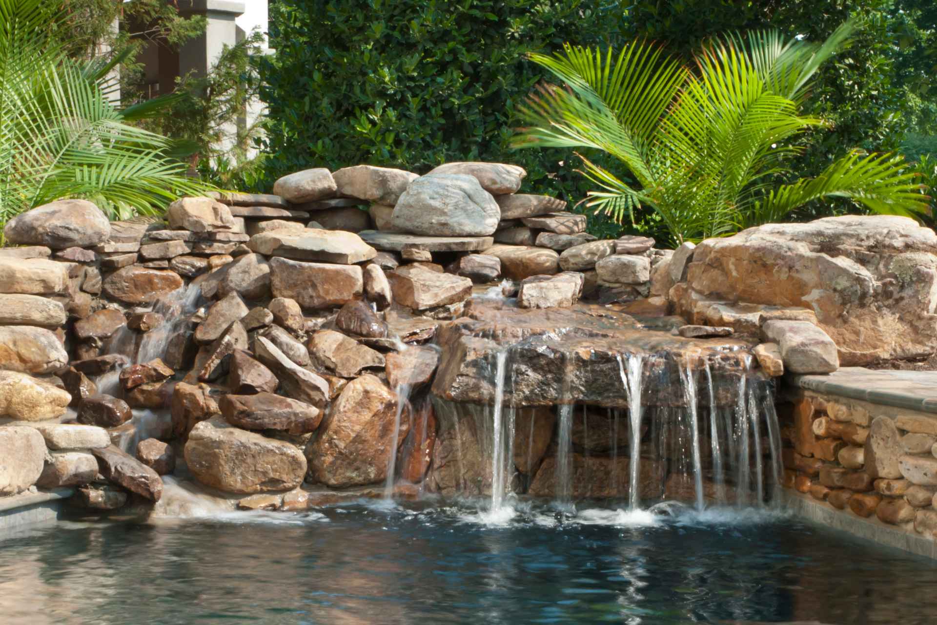 Beautiful backyard pond with a waterfall feature, showcasing the importance of choosing the right pond pump.